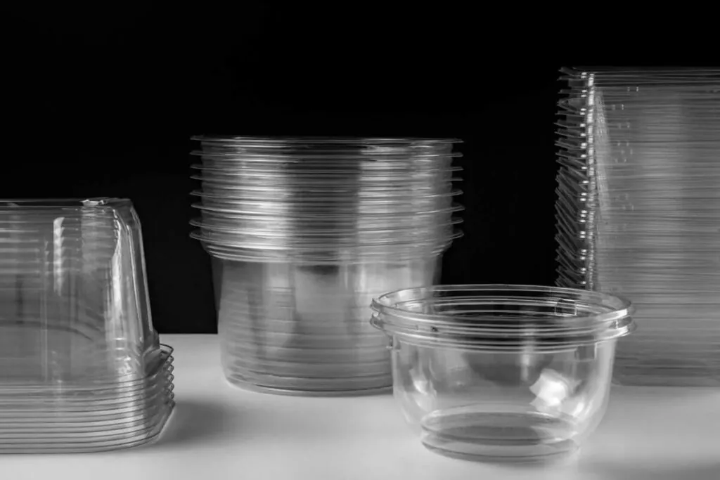 Stacks of clear plastic food packaging containers and bowls that food packaging certification standards apply to